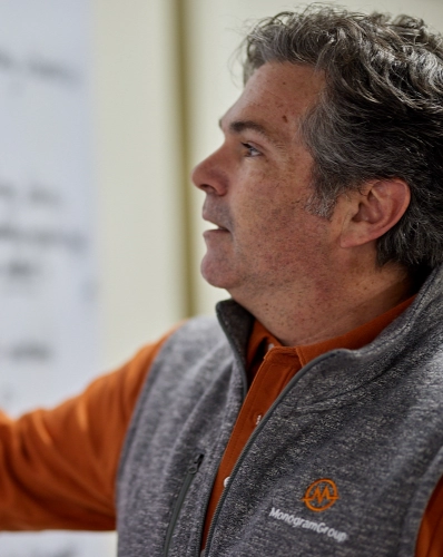 MonogramGroup Hero Photo of Partner/Creative Director, Chip Balch, writing down information he's explaining on a white board during an internal meeting at the office.